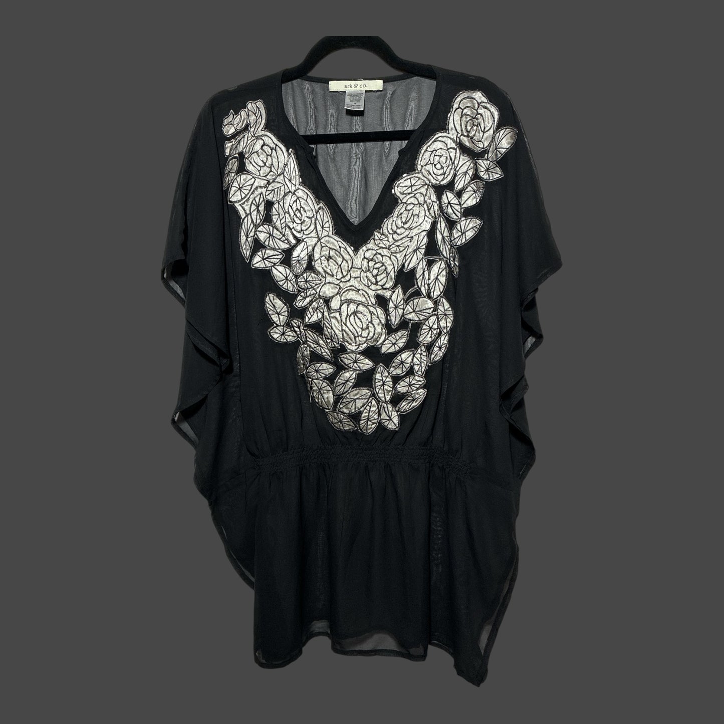 But I Wish It Was Black sheer black tunic with white floral embroidery, V-neck, and flutter sleeves on a hanger.