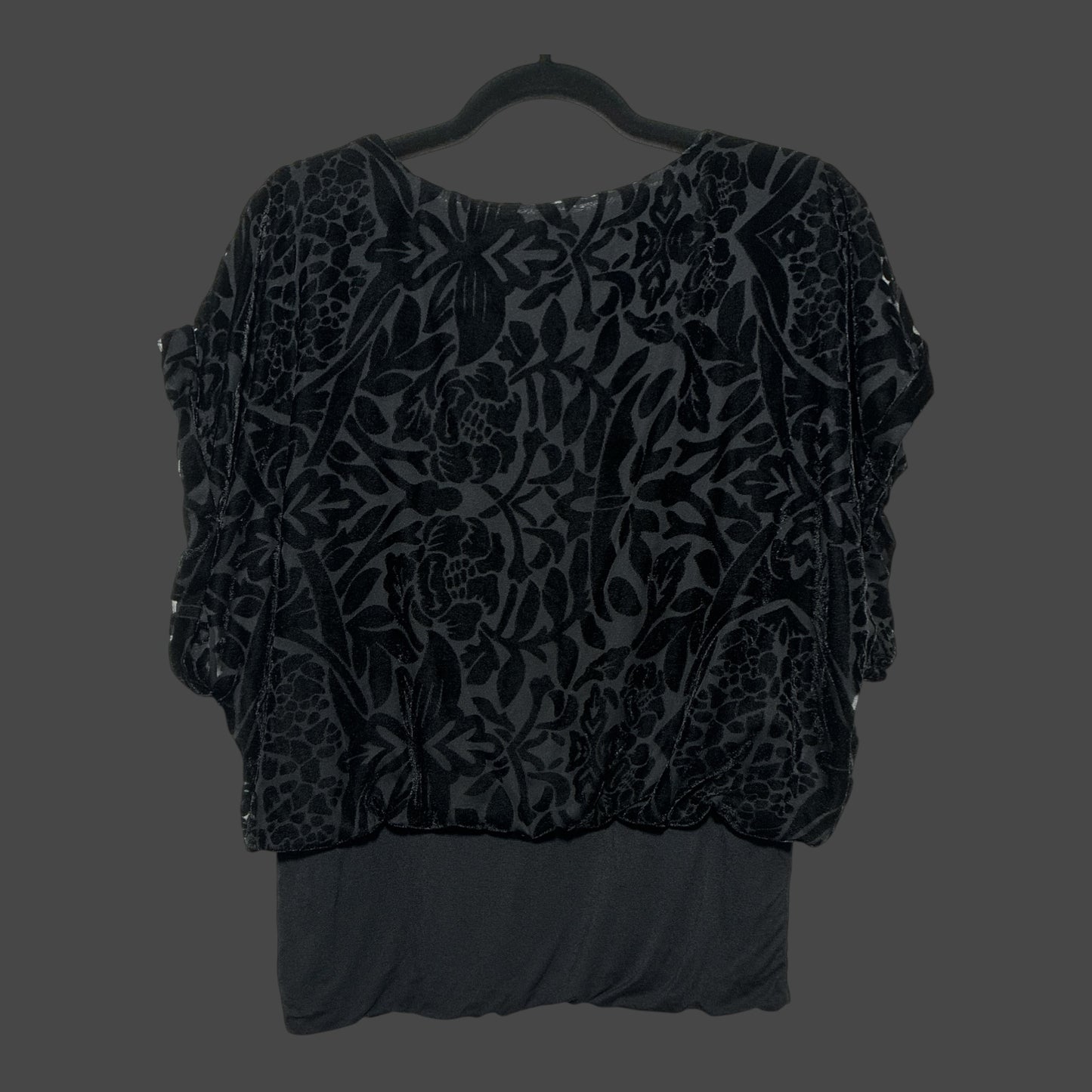 But I Wish It Was Black short sleeve blouse in black velvet with a textured floral burnout pattern on a hanger.